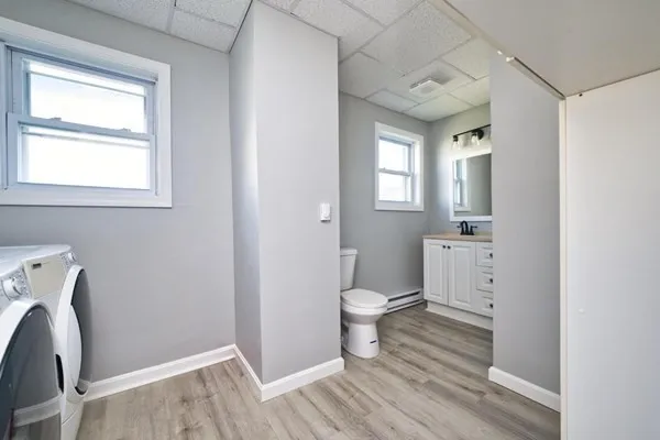 a bathroom with a toilet sink a mirror and a window