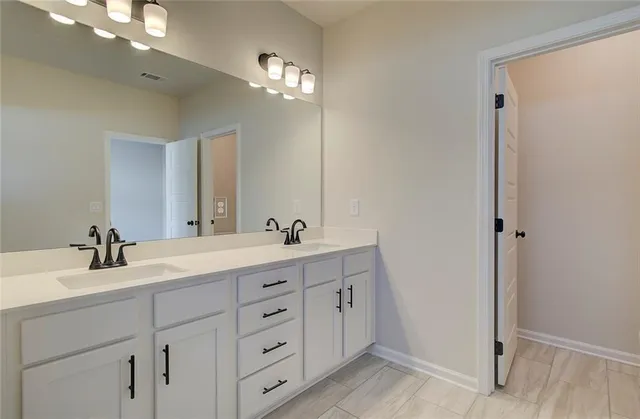 a bathroom with a double vanity sink and mirror