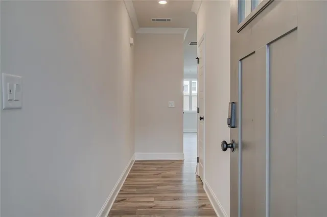 a view of a hallway with wooden floor and staircase