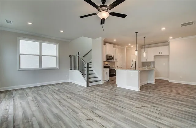 a view of kitchen with stainless steel appliances refrigerator stove and wooden floor