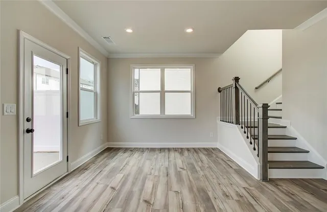 a view of hallway with a large window and wooden floor