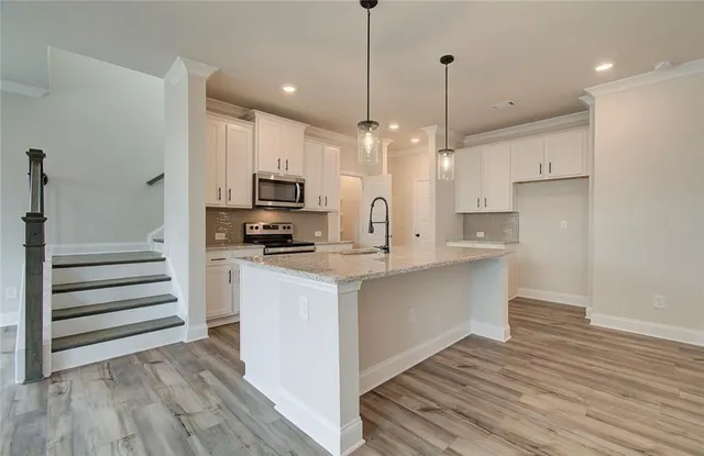 a kitchen with kitchen island a sink stainless steel appliances and cabinets