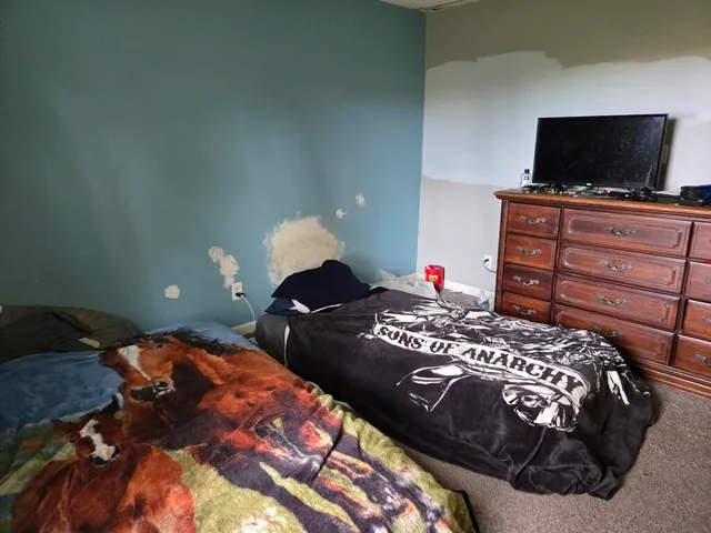 a bedroom with a bed and a flat screen tv