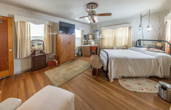 a spacious bedroom with a bed a couch and dresser