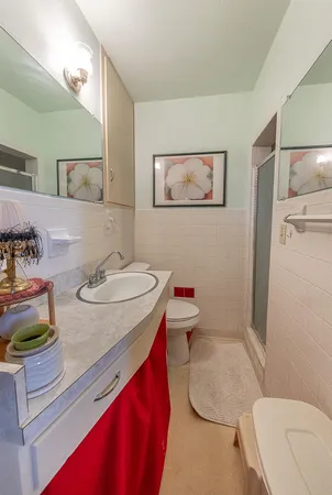 a bathroom with a granite countertop toilet sink and mirror