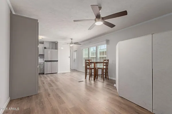 a view of a kitchen with wooden floor and a refrigerator