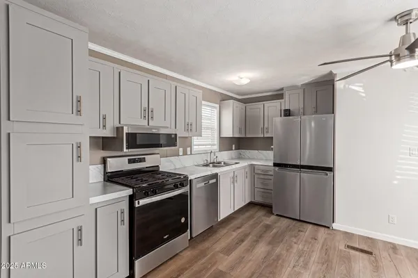 a kitchen with cabinets appliances and a wooden floor