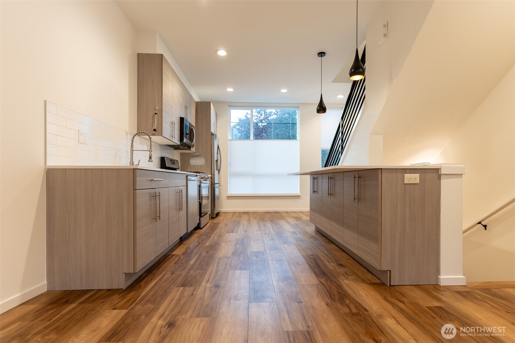 9030 18th Avenue Southwest, Unit B Seattle, WA 98106 - Photo 3 of 20 a kitchen with wooden floors and cabinets