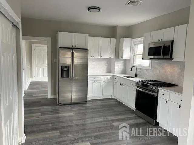 a kitchen with stainless steel appliances granite countertop a refrigerator and a stove top oven
