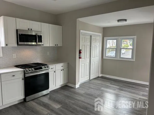 a kitchen with white cabinets and stainless steel appliances