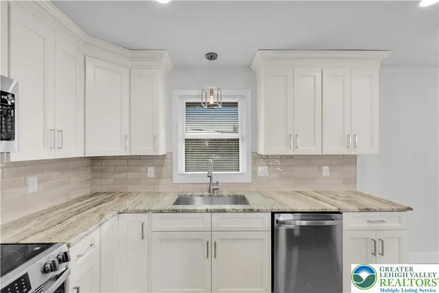 a kitchen with granite countertop a sink stainless steel appliances and cabinets