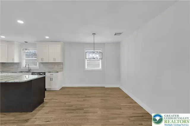 a kitchen with kitchen island granite countertop a sink window and refrigerator