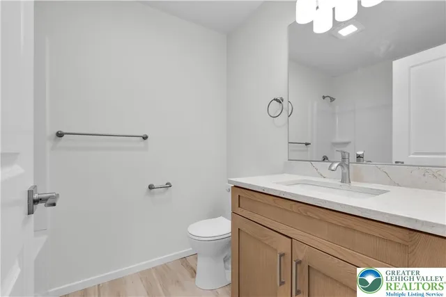 a bathroom with a granite countertop sink a toilet and a mirror