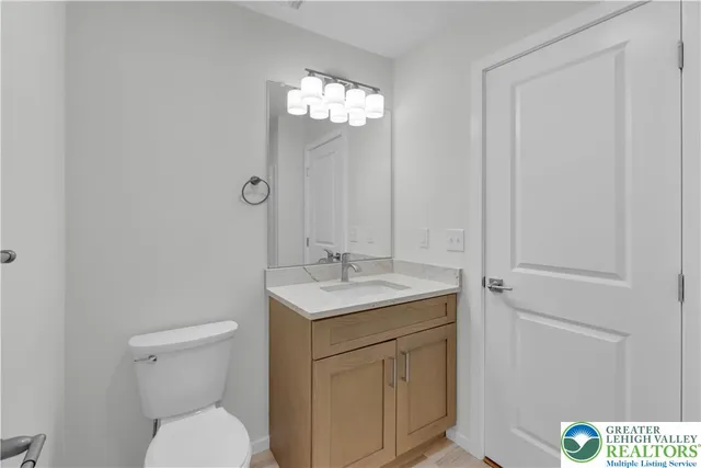 a bathroom with a toilet a sink and mirror