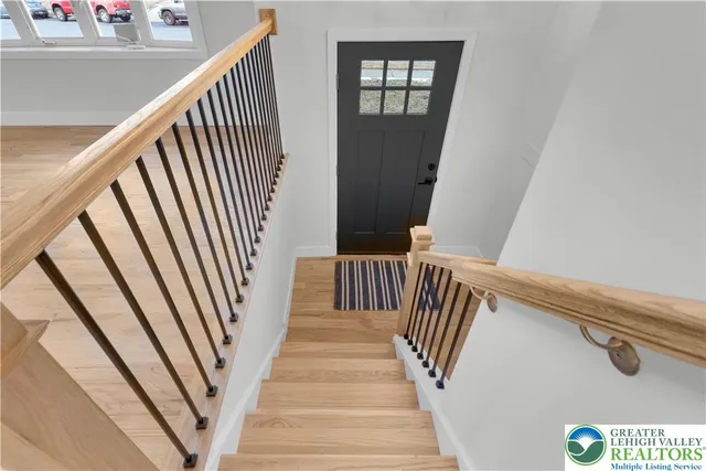 a view of staircase with railing and white walls