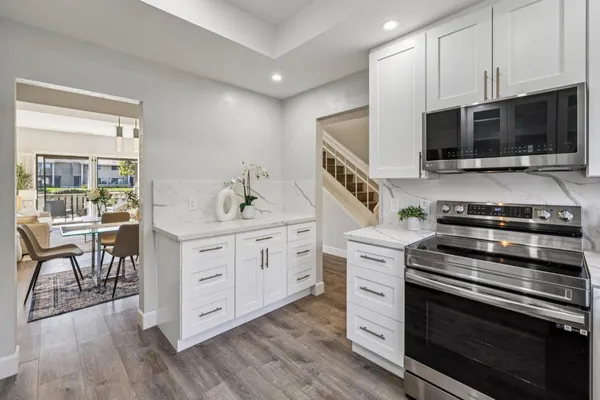 a view of a dining room with furniture a chandelier and wooden floor