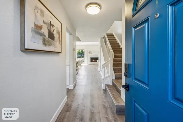 a view of a hallway with wooden floor and stairs