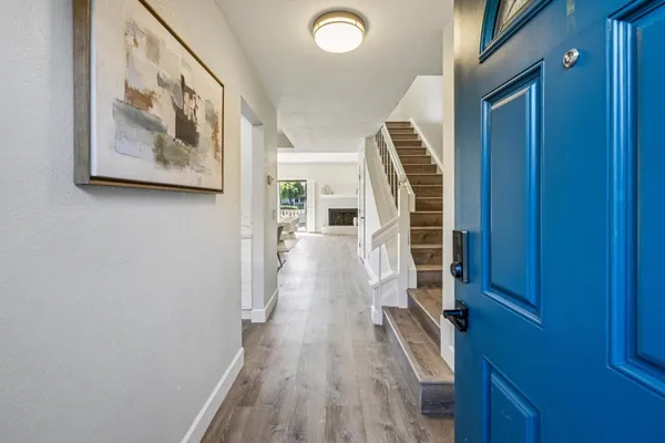a view of a hallway with wooden floor and stairs