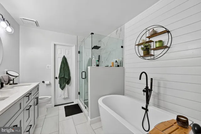 a bathroom with a sink and mirror with bathtub