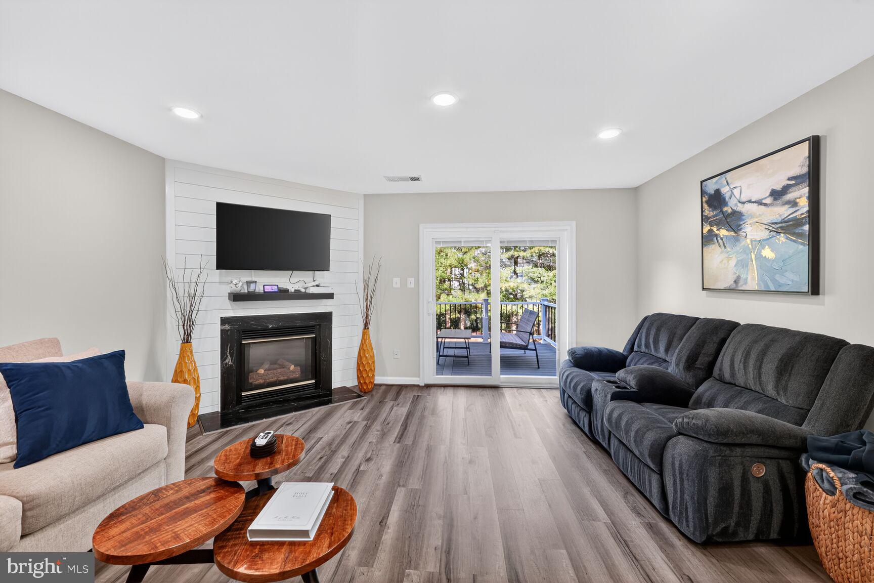 13486 Grouserun Lane Bristow, VA 20136 - Photo 13 of 20 a living room with furniture a fireplace and a flat screen tv