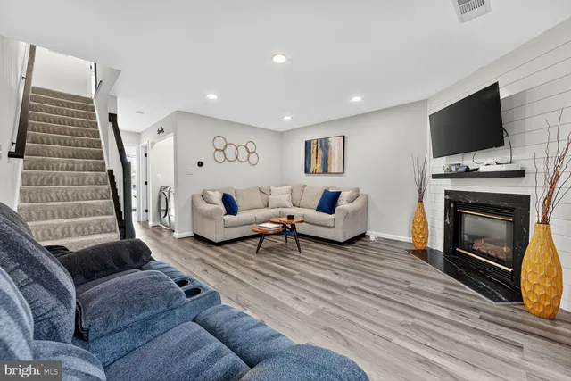 a living room with furniture a flat screen tv and a fireplace