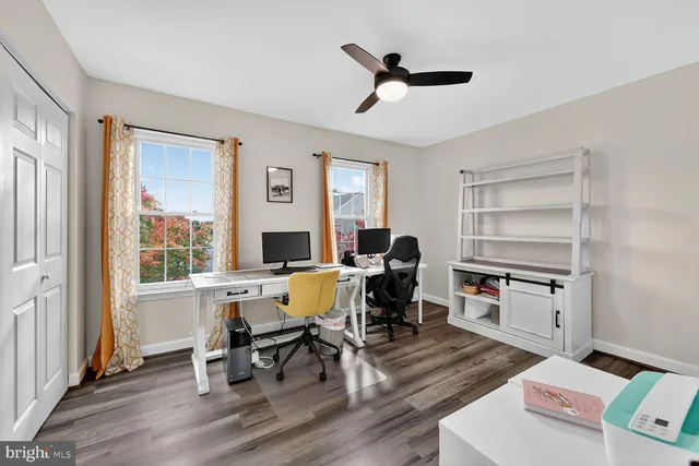 a view of a workspace with furniture and a window