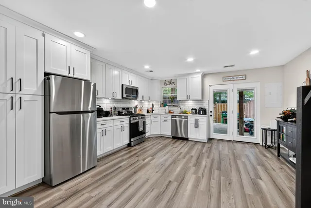 a kitchen with stainless steel appliances a refrigerator sink and cabinets