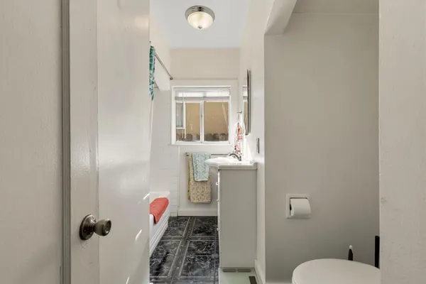 a bathroom with a toilet sink and mirror