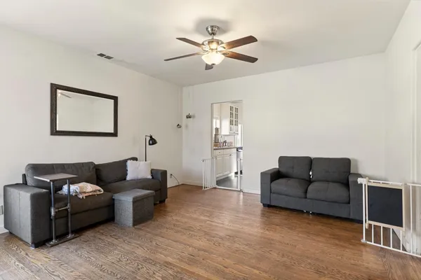 a living room with furniture and a ceiling fan