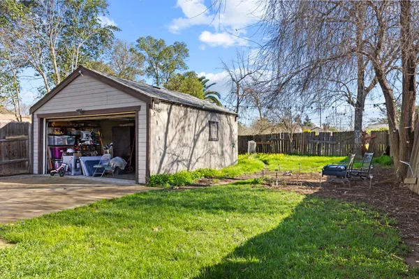a view of a chair and table in backyard of the house