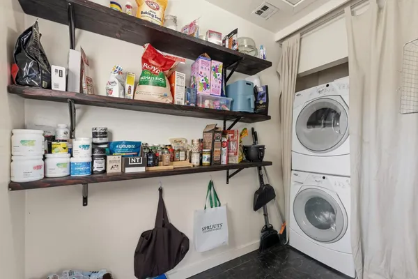 a view of a storage and utility room with sink dryer and washer