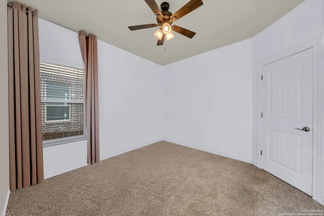 a view of a room with a ceiling fan and a window