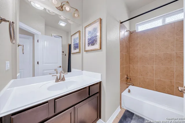 a bathroom with a bath tub sink mirror and a shower