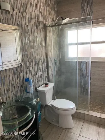 a bathroom with a toilet and a shower