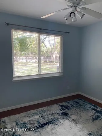a view of a big room with wooden floor and windows