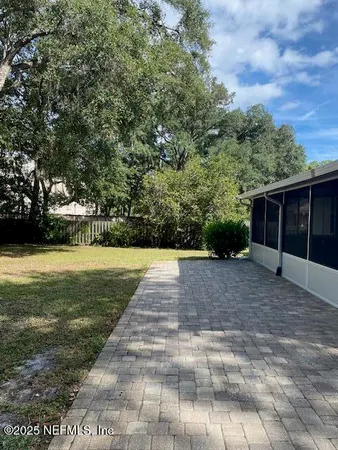 a view of a yard with plants and trees