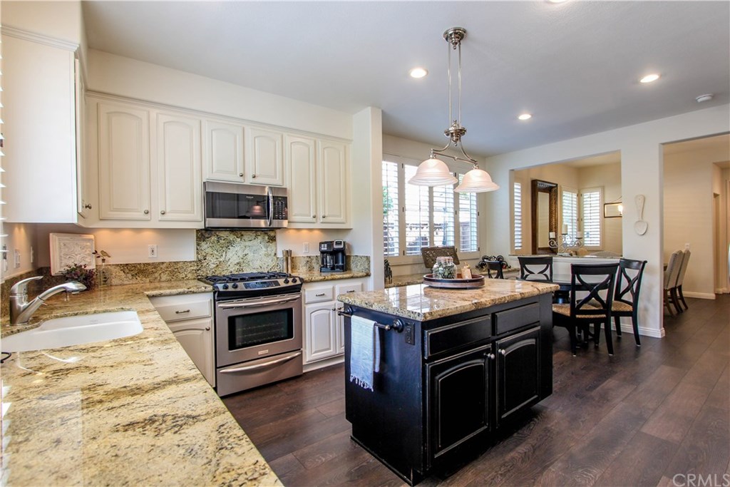 7 Earlywood Ladera Ranch, CA 92694 - Photo 4 of 33 White Cabinets with Dark Stained Center Island