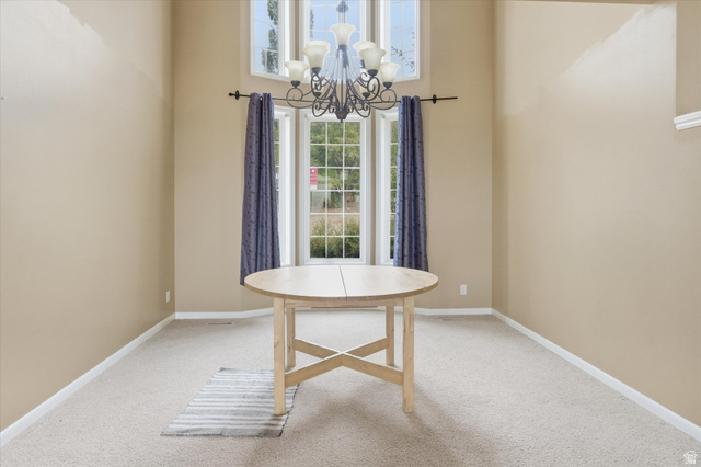 2887 View Crest Circle North Logan, UT 84341 - Photo 8 of 37 Dining area with light carpet, a high ceiling, and hanging lights