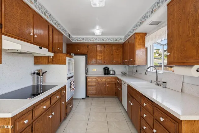 a large kitchen with stainless steel appliances sink a microwave and cabinets