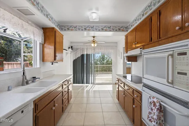 a large kitchen with a large window and stainless steel appliances