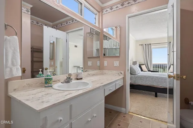 a en suite bathroom with a granite countertop sink and a mirror