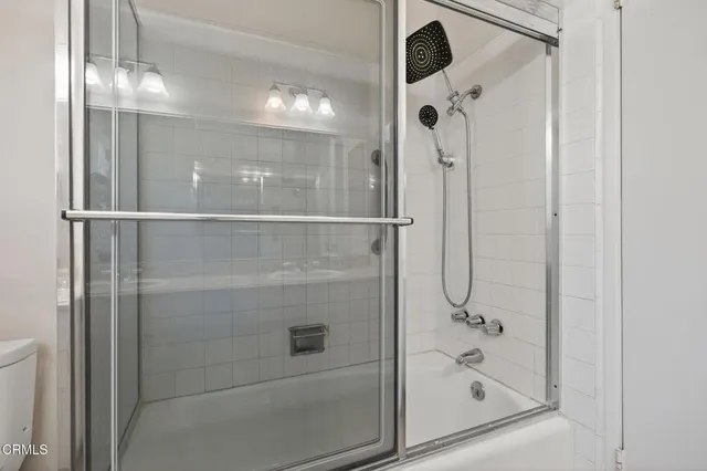a bathroom with a glass shower door and a mirror