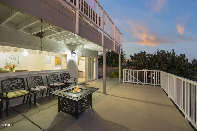 a backyard of a house with barbeque oven table and chairs