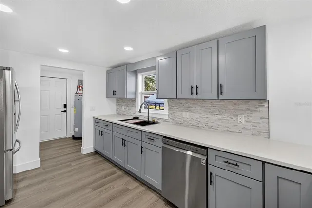 an empty room with wooden floor ceiling fan and window