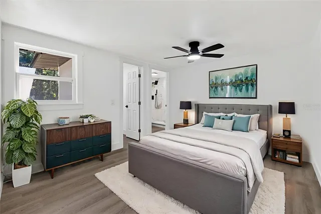 an empty room with wooden floor ceiling fan and window
