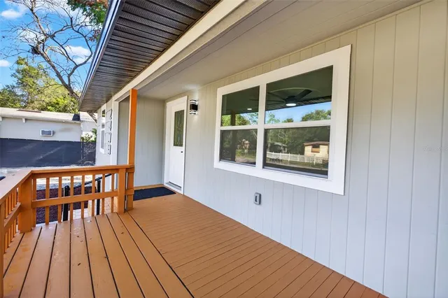 a view of empty room with wooden floor and window