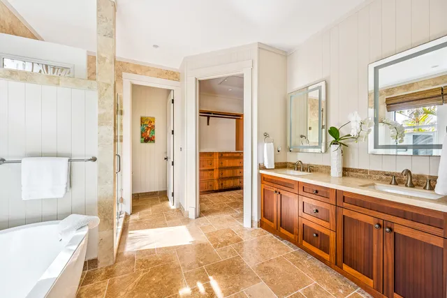 a spacious bathroom with a tub sink and mirror