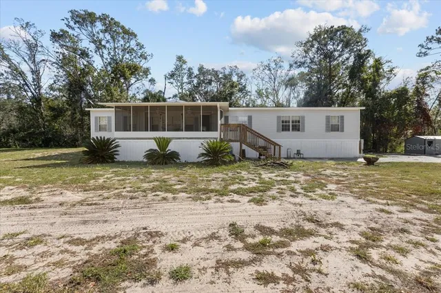 a view of a house with backyard and trees