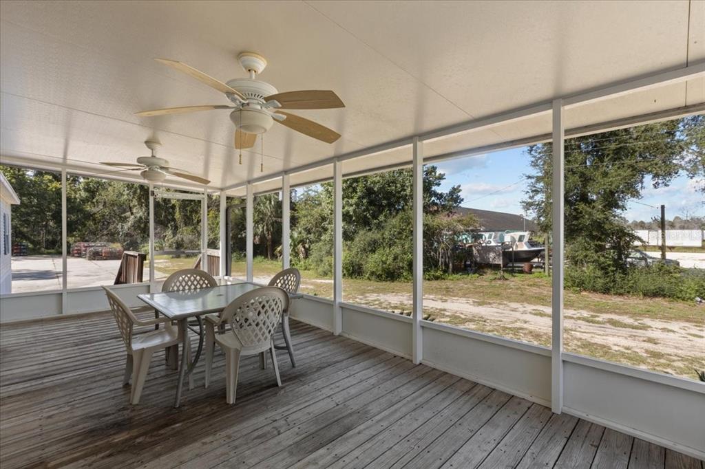 4945 Southwest Highway 358 Steinhatchee, FL 32359 - Photo 28 of 33 a dining room with wooden floor a chandelier a glass table and chairs
