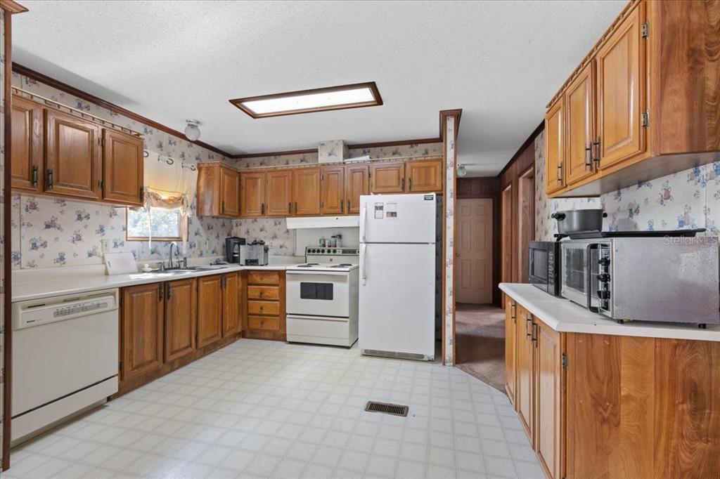 4945 Southwest Highway 358 Steinhatchee, FL 32359 - Photo 6 of 33 a kitchen with refrigerator cabinets and a sink